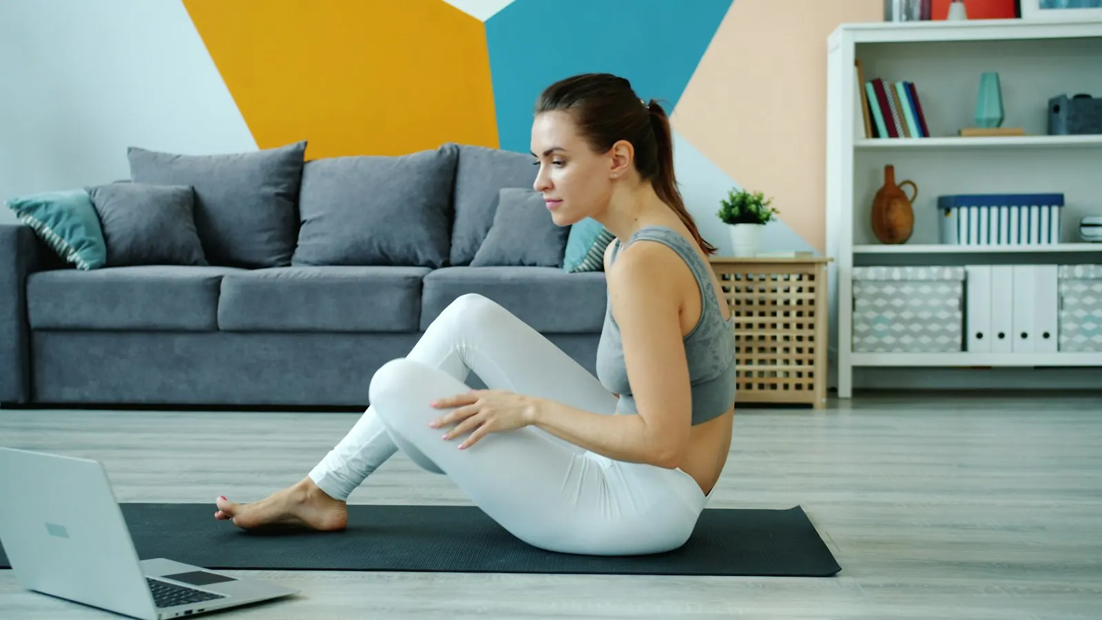 Evde laptop karşısında yoga pratiği